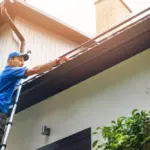 man cleaning gutters