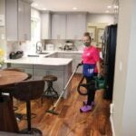 employee vacuuming the kitchen